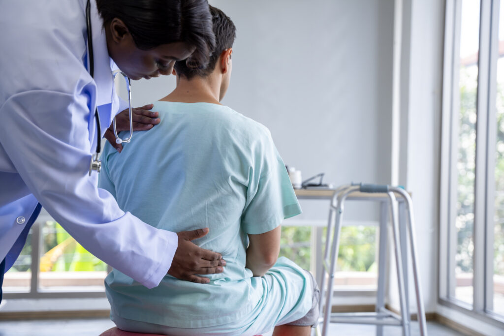 Doctor attending to male patient with back injury