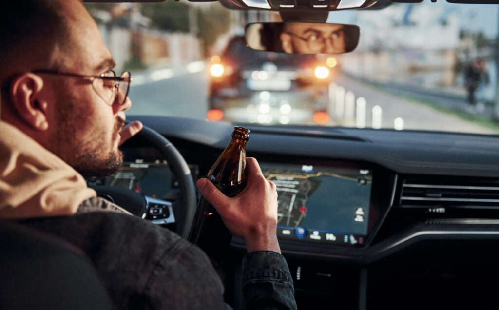 Man drinking alcohol while driving