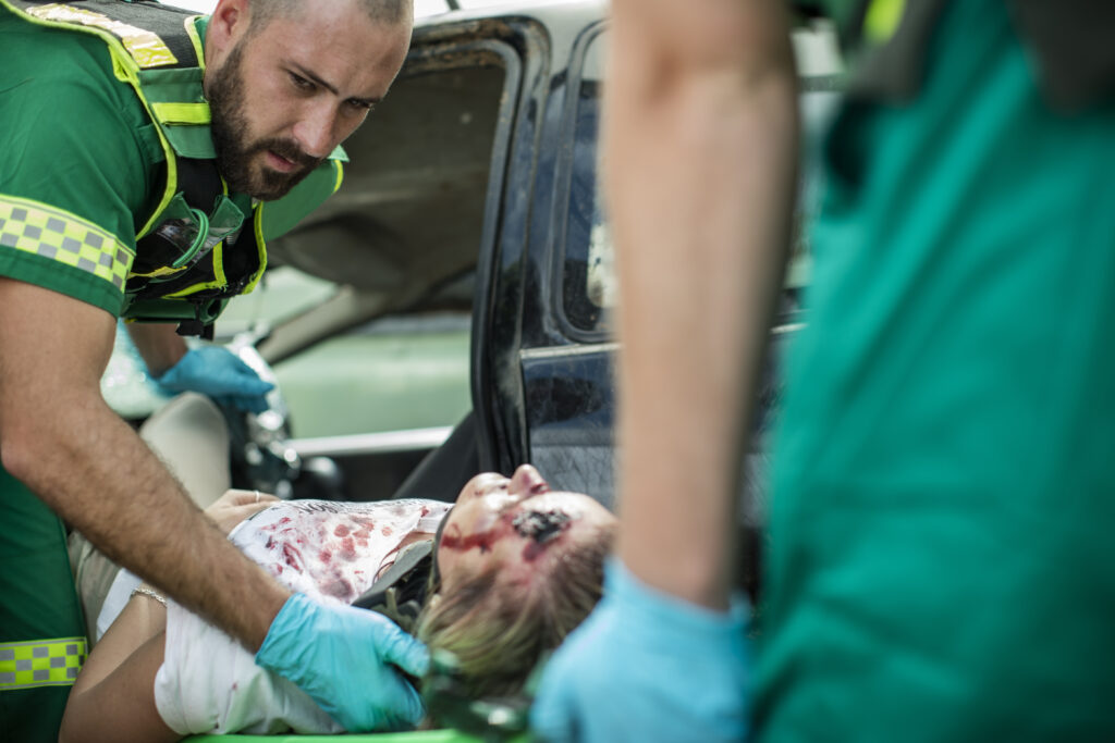 Paramedics moving car crash victim on stretcher